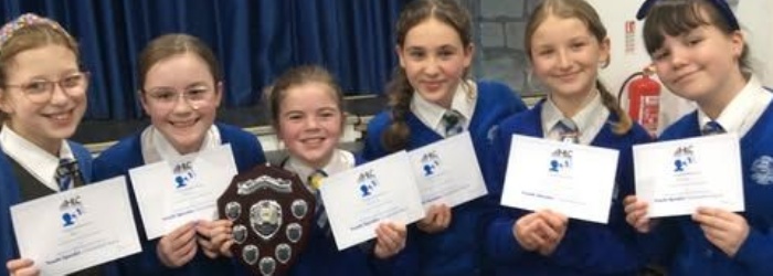 Students from Honiton Community College holding trophy and certificates from winning the Youth Speak Competition